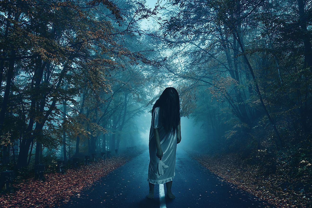 Zombie girl walking in a spooky forest.