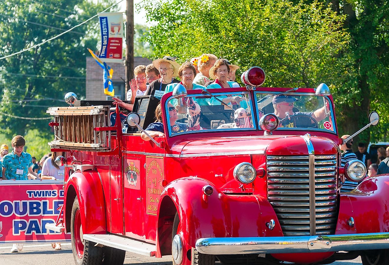 Elderly twins ride in an old-fashioned fire truck in the Double Take Parade, in Twinsburg, Ohio. Image credit Kenneth Sponsler via Shutterstock