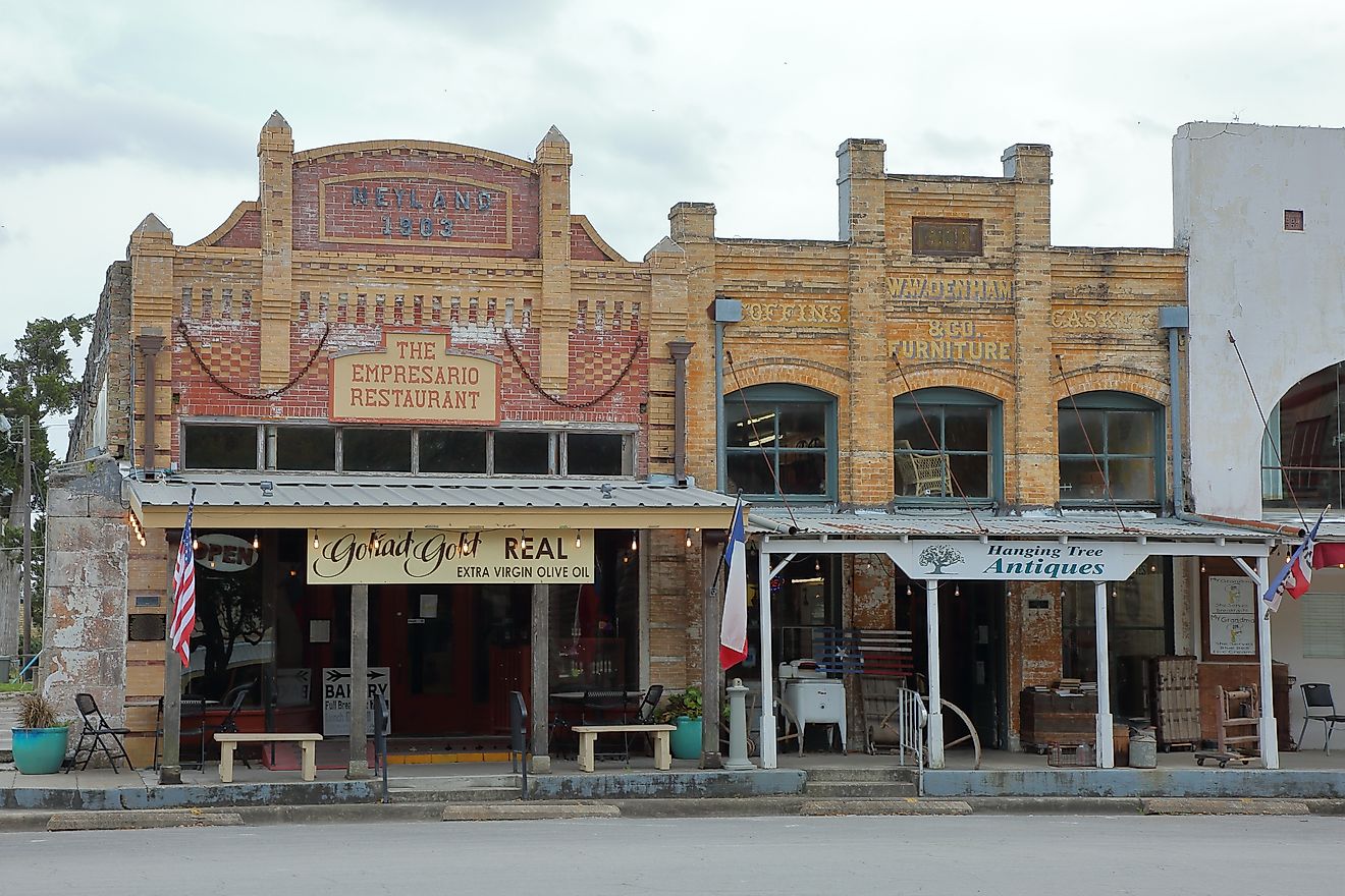 The Empresario Restautant and Hanging Tree Antiques buildings in the downtown historic courthouse square - Goliad, Texas, via JustPixs / Shutterstock.com