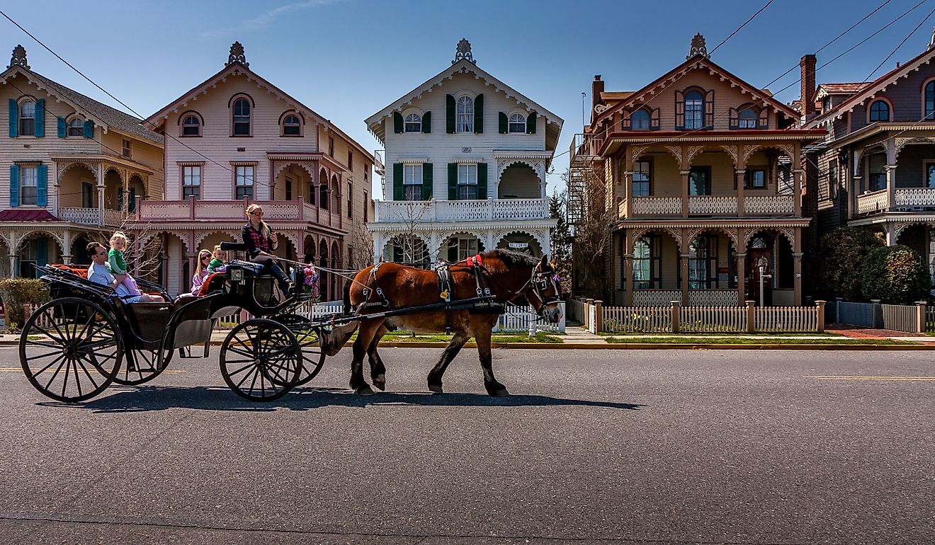 A carriage carries tourists past a row of Victorian "gingerbread" houses typical of Cape May, NJ. Editorial credit: Steve Rosenbach / Shutterstock.com