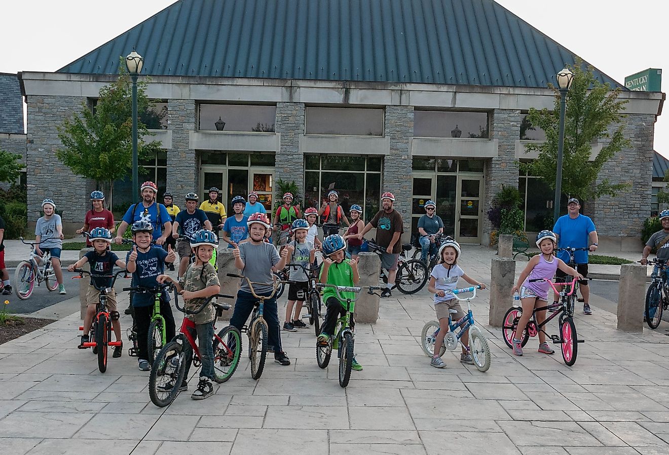 A group of kids participating in a pedal with the police event posing in front of the Kentucky Artisan Center. Image credit Steven J Hensley via Shutterstock