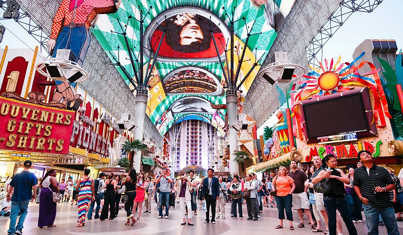 Tourists outside the Pioneer Cowboy Vegas Vic neon sign watch the Freemont Street Experience. Editorial credit: Paul Maguire / Shutterstock.com