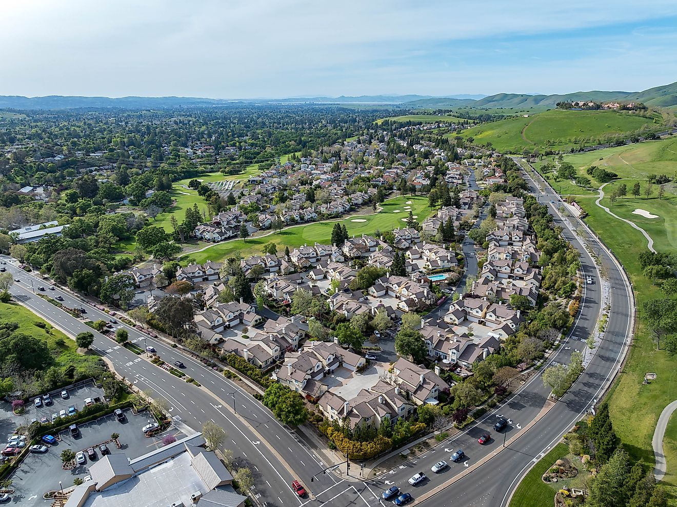 Drone photos capturing the Oakhurst neighborhood in Clayton, California, featuring green hills, a golf course, and residential homes.