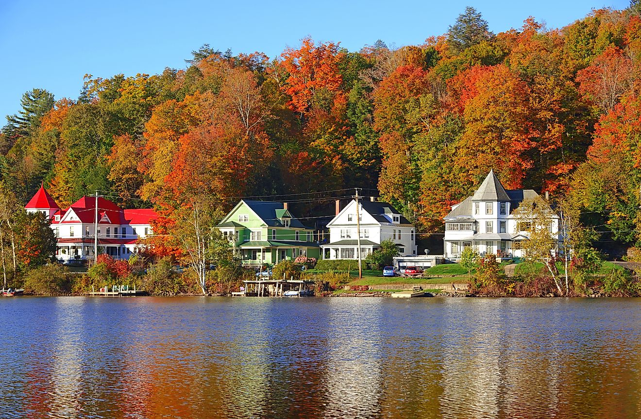 Waterfront homes and fall foliage along Saranac Lake in New York.