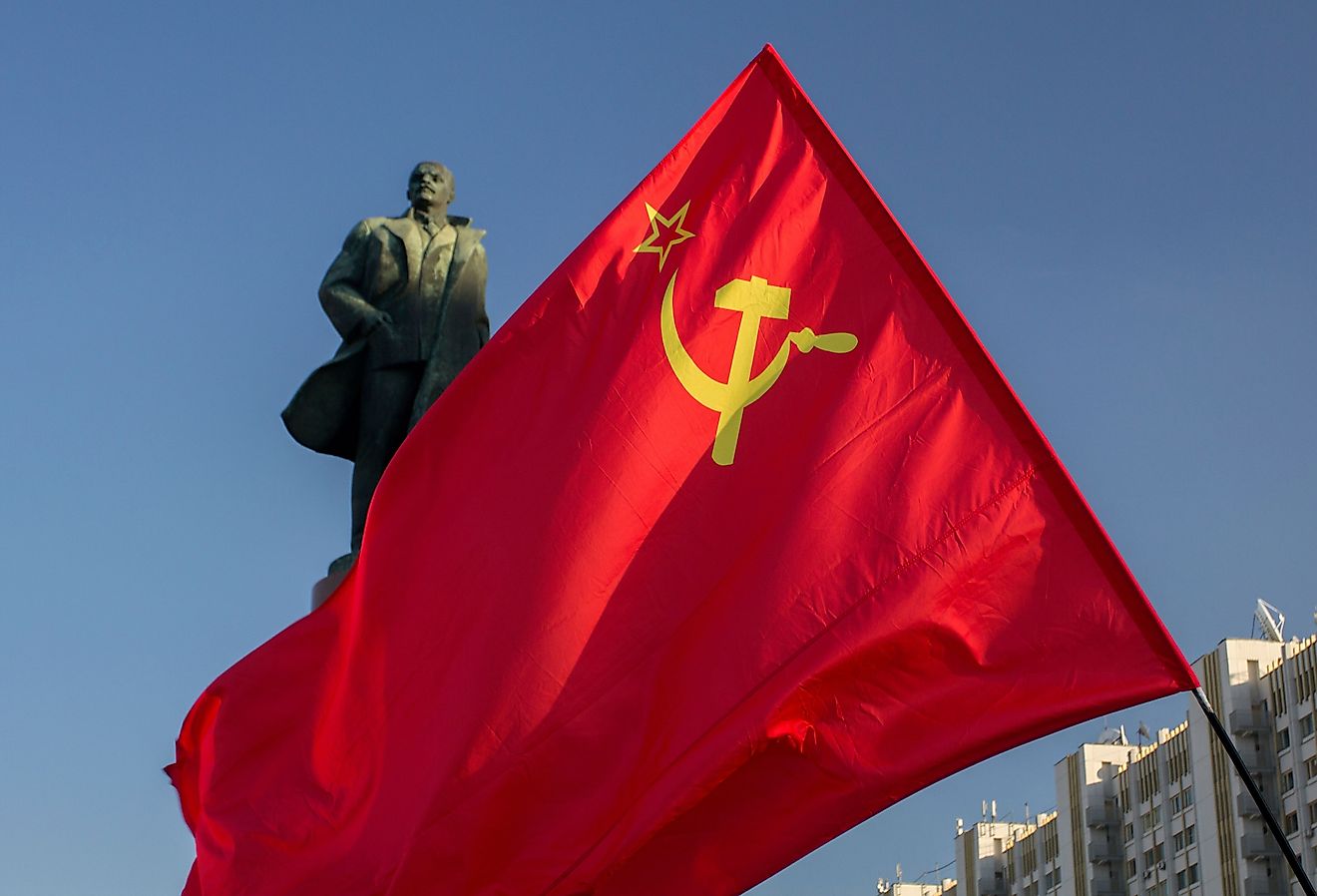 The flag of the Soviet Union (USSR) waving in the wind against the background of the monument to Lenin.