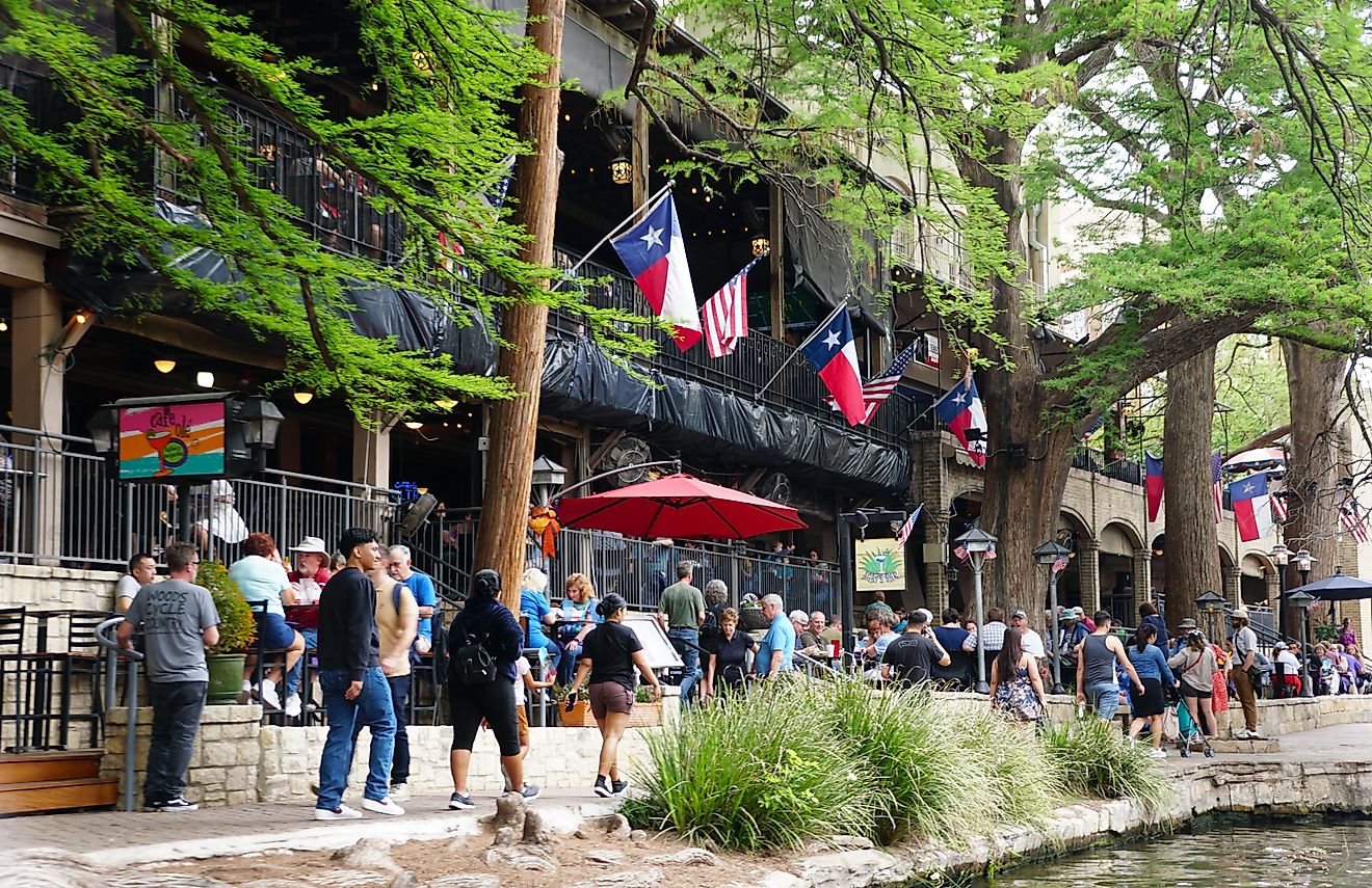 San Antonio, Texas: Visitors walking next to the bars and restaurants along the river walk, via Khairil Azhar Junos / Shutterstock.com
