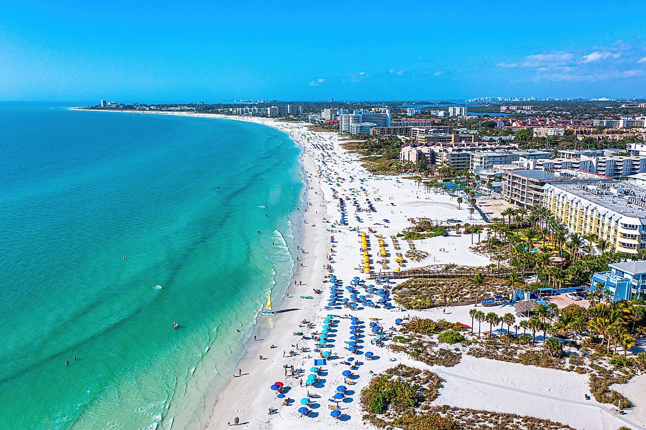 Siesta Key Beach in Sarasota, Florida, on a beautiful sunny day during spring break, with bright blue water, boats, and white sands.