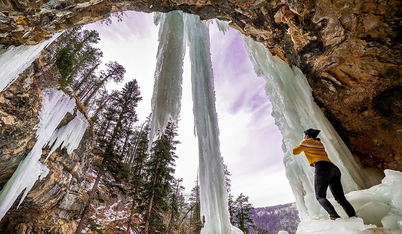 Girl standing under a frozen waterfall in Spearfish, South Dakota. 