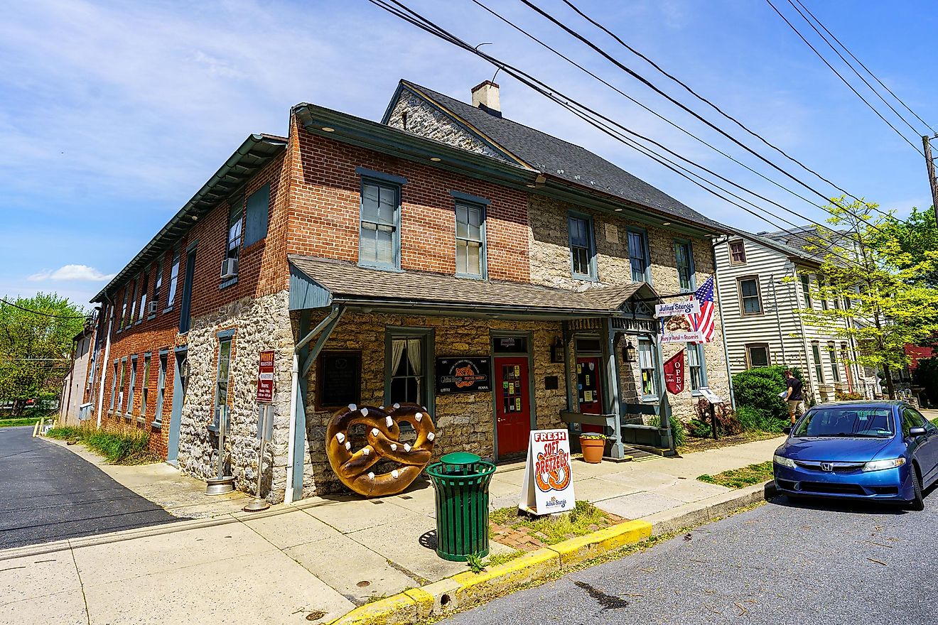 Exterior view of the Julius Sturgis Pretzel Bakery, the first commercial pretzel bakery in the US, with a distinctive large pretzel sign.