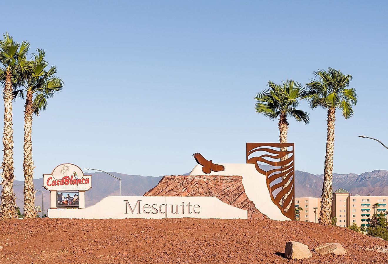 A Mesquite, Nevada welcome sculpture and palm trees fronts the Casablanca Resort & Casino with mountains rising in the background. Image credit Steve Lagreca via Shutterstock.