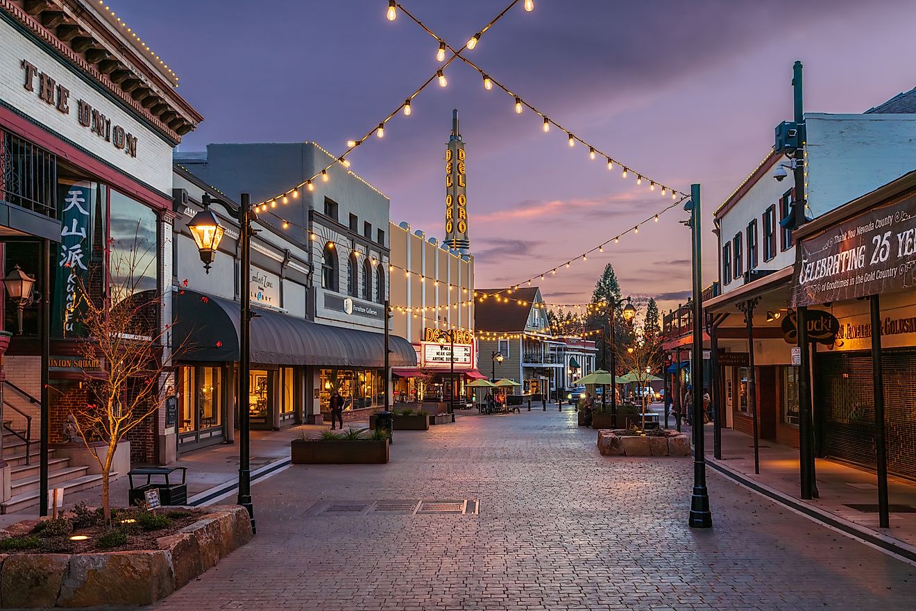 The Plaza on Mill Street in Grass Valley, California, at dusk, featuring warmly lit storefronts and a peaceful atmosphere. Editorial credit: Cavan-Images / Shutterstock.com