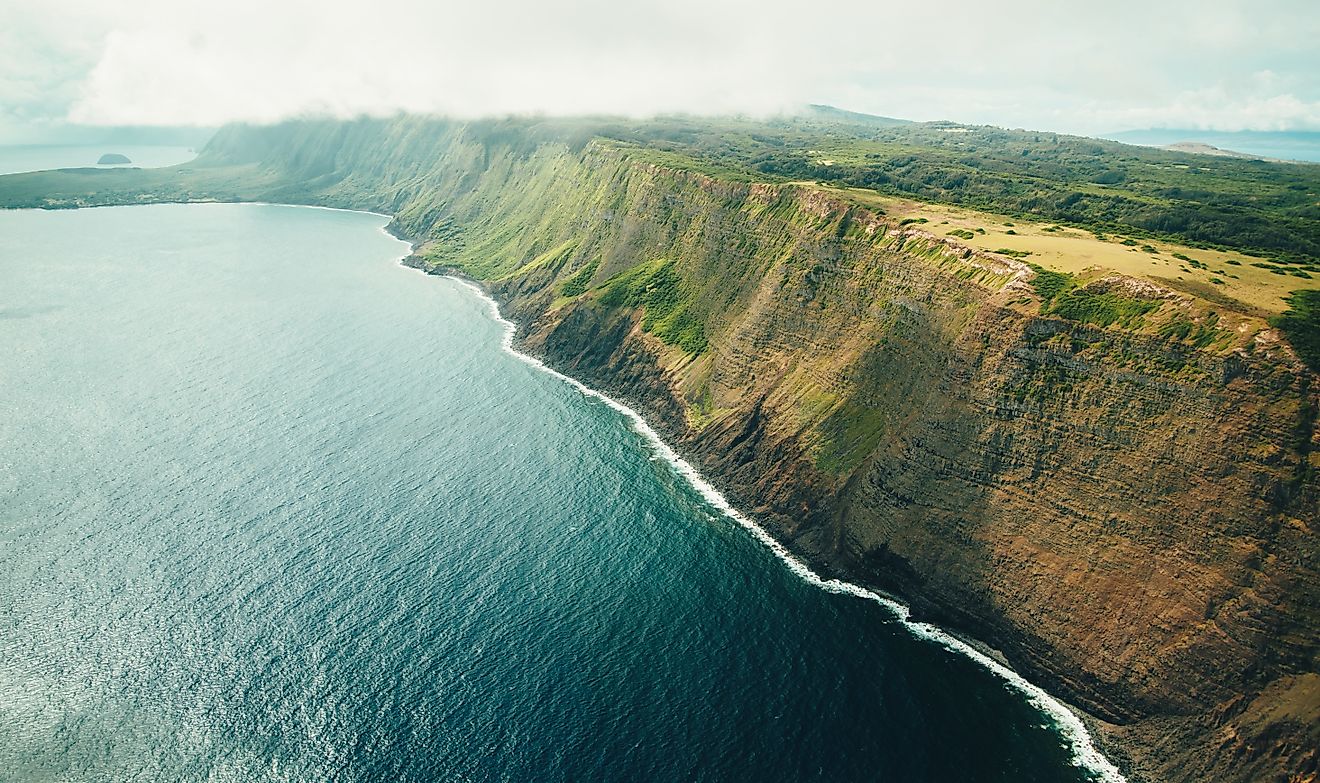 Aerial view of Molokai's sea cliffs with deep blue ocean below, showcasing the tropical island paradise of Hawaii.