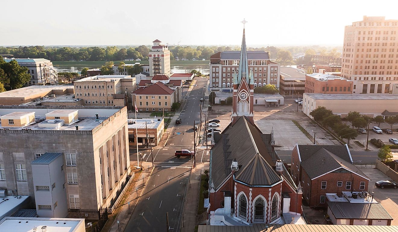 Afternoon sunlight shines on the historic buildings and church in the skyline of downtown Monroe.