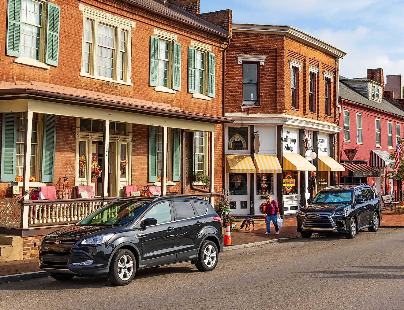 A woman and her dog walk along main street in Jonesborough decorated for Thanksgiving.