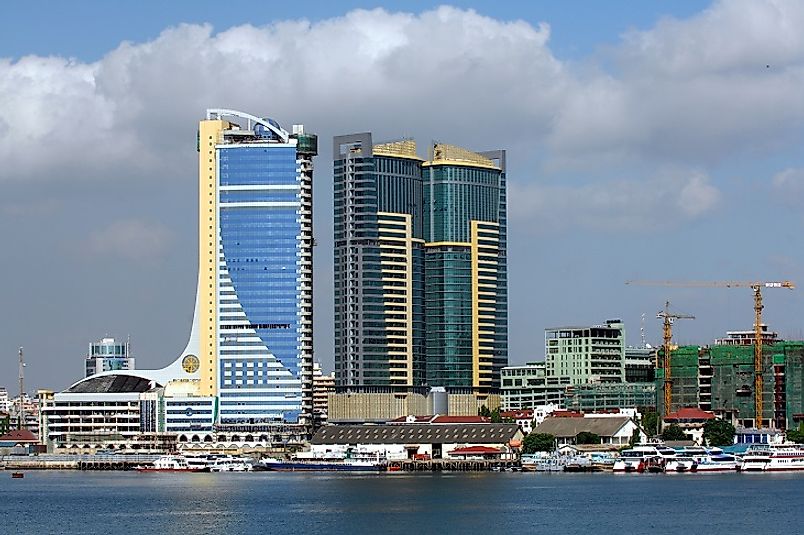 Massive Tanzanian skyscrapers dwarf the boats in Dar es Salaam's Indian Ocean harbor below them.