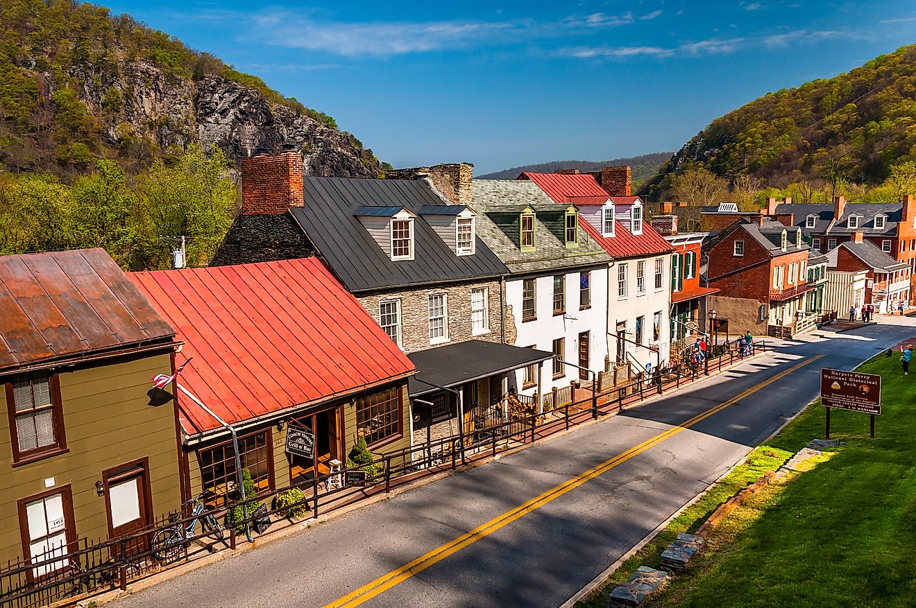 Main Street in Harpers Ferry, West Virginia, lined by colorful historical buildings housing local businesses.