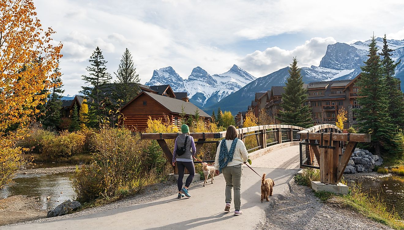 Residents walking the dogs in Town of Canmore in fall season. Image Credit Shawn.ccf via Shutterstock.