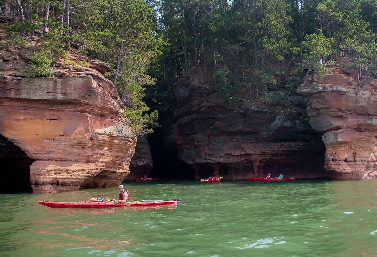 Kayakers enjoy the Apostle Island National Sea Caves in Bayfield, Wisconsin. Image credit Jacob Boomsma via Shutterstock.
