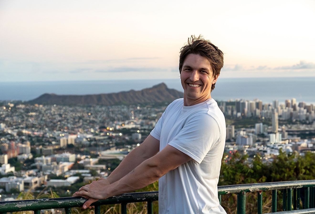 Student smiling with the cityscape of Honolulu in the background.