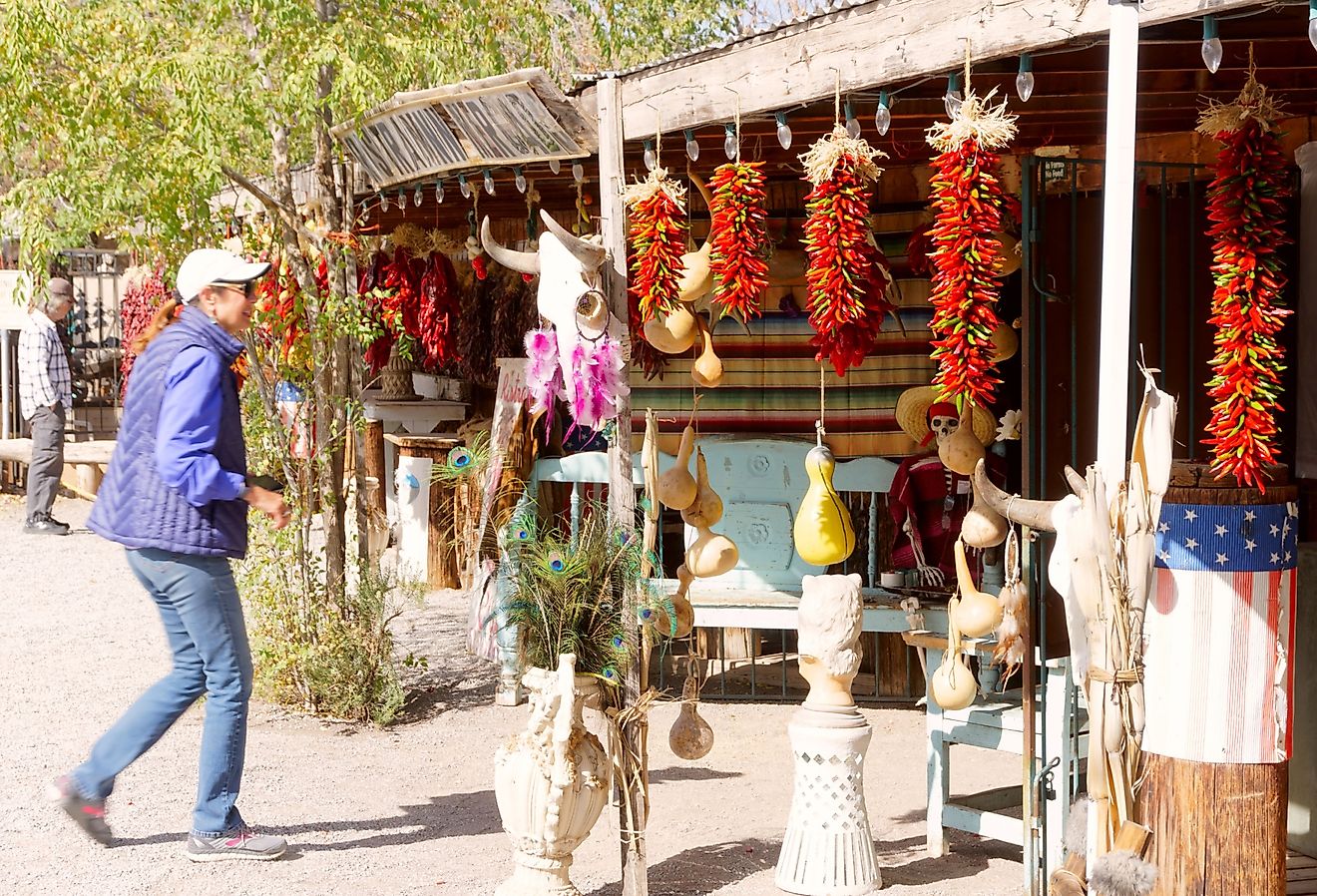 Tourist looking at the ristras hanging in front of a store in Mesilla, New Mexico. Image credit Grossinger via Shutterstock.