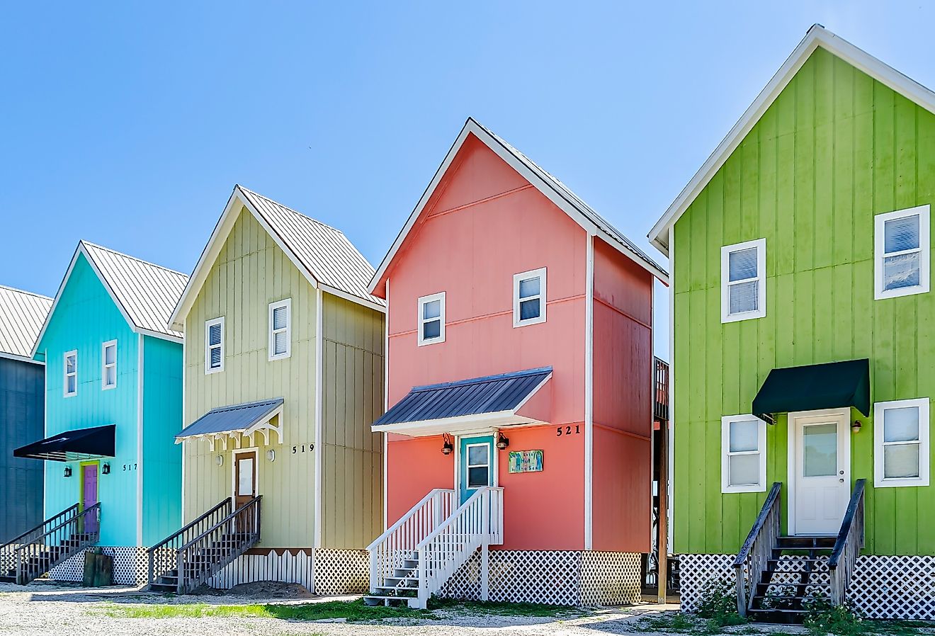 A row of colorful beach houses known as “The Birdhouses” overlook Bayou Aloe, in Dauphin Island, Alabama. Image credit Carmen K. Sisson via Shutterstock