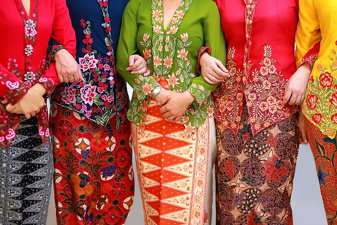  Five women wearing traditional Indonesian clothing, including a kebaya, kain batik, and songket.