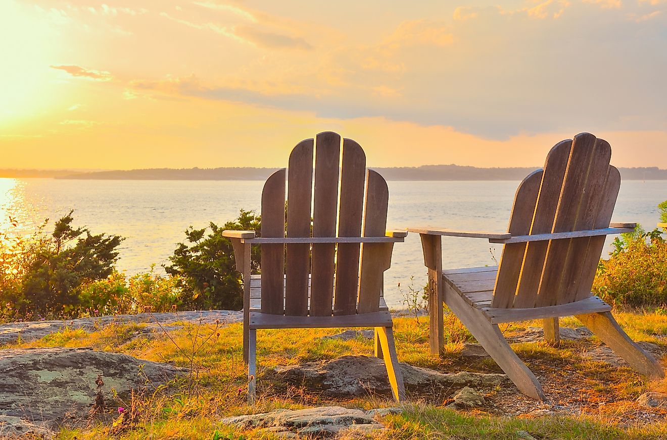 Adirondack chairs on cliff overlooking the water Narragansett Bay at sunset, late summer, early fall, golden hour Newport, Rhode Island