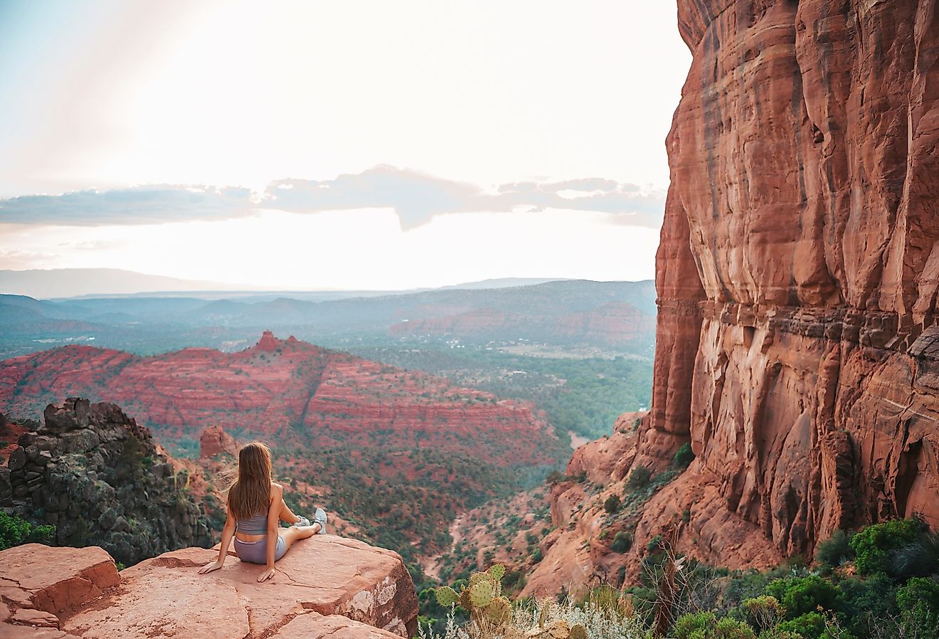 Girl on the edge of Cathedral Rock at sunset in Sedona, Arizona.