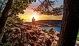 A silhouette of a man looking out into the sunset over Devils Lake State Park from a hiking viewpoint in Baraboo, Wisconsin USA.