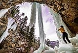 Girl standing under frozen waterfall in Spearfish, South Dakota.