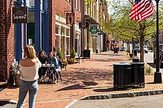 A thin, blonde woman takes a picture of two friends seated at a sidewalk table in front of the Downtown Sweet coffee shop. Editorial credit: Nolichuckyjake / Shutterstock.com