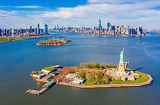 Aerial view of Statue of Liberty, Ellis Island, and Lower Manhattan skyline from New York Harbor near Liberty State Park in New Jersey. 