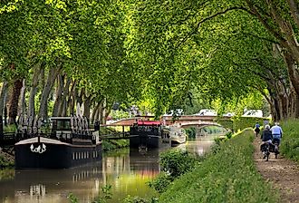 Cyclists and pedestrians line the Canal du Midi. Image credit thieury via Shutterstock.