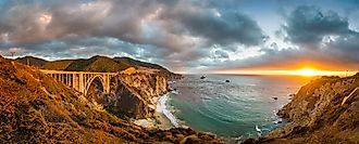 Scenic panoramic view of historic Bixby Creek Bridge along world famous Highway 1 in beautiful golden evening light at sunset with dramatic cloudscape in summer, Monterey County, California, USA