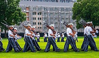 Groups of Army cadets in formation holding rifles and marching on the West Point Military Academy parade field. Editorial credit: Alan Budman / Shutterstock.com