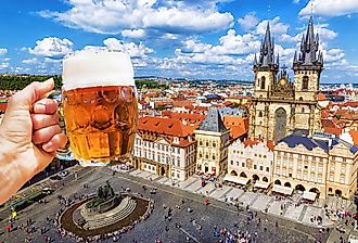 Mug of beer on the background of the Old Town Square in Prague, Czechia.