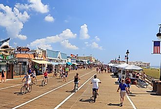 People walking and biking along the boardwalk in Ocean City, New Jersey. Image credit Vlad G via Shutterstock