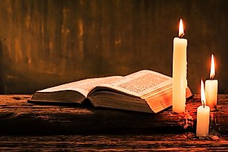 Bible and candle on an old oak table. 