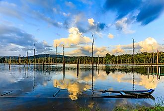 Lake Brokopondo in Suriname. Sunken canoe and reflection of sky in water. Image credit Rene via Shutterstock.