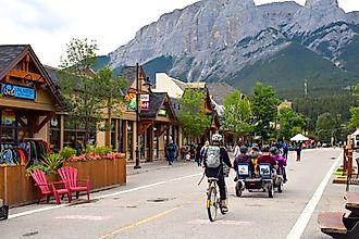 Tourists riding bicycles on a street of Canmore. Editorial credit: JulieK2 / Shutterstock.com.