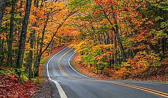 A tunnel of vibrant autumn trees lines the scenic byway M41 on the Keweenaw Peninsula in Michigan's Upper Peninsula.