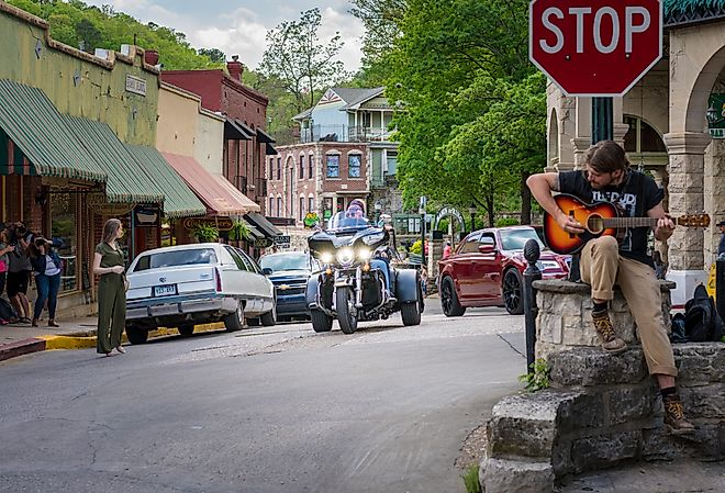 Biker visitors riding motorcycle downtown Eureka Springs, Arkansas. Image credit shuttersv via Shutterstock