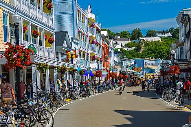 The bikes, horse-drawn carriages, and colorful establishments of Mackinac Island's Main Street, with Fort Mackinac standing proud on the hill in the distance. Photo: Dennis MacDonald