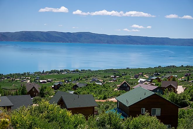 View of Bear Lake from the Idaho side, with a cabin on the hillside overlooking the lake.