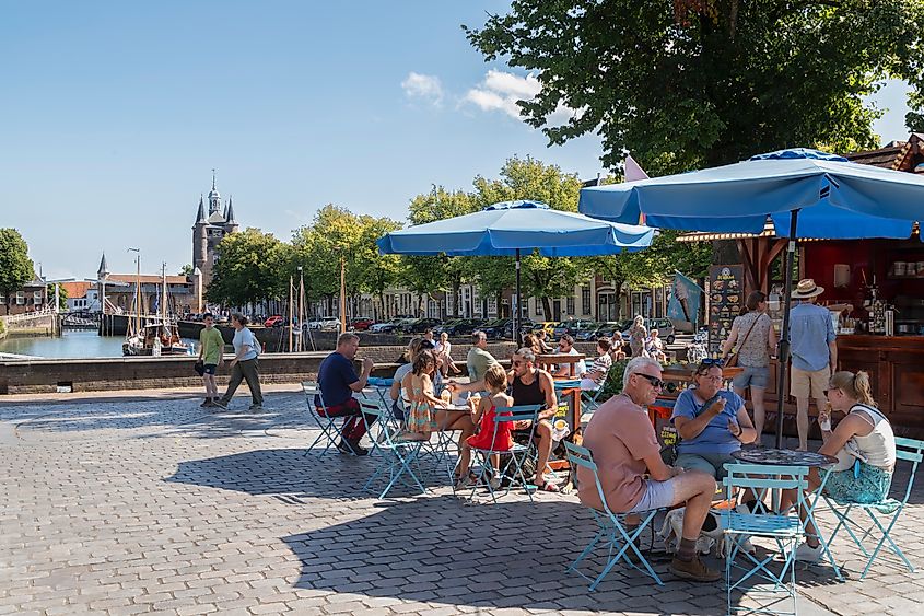 People enjoying the pleasant weather on a terrace along the harbor in the historic city of Zierikzee, Netherlands