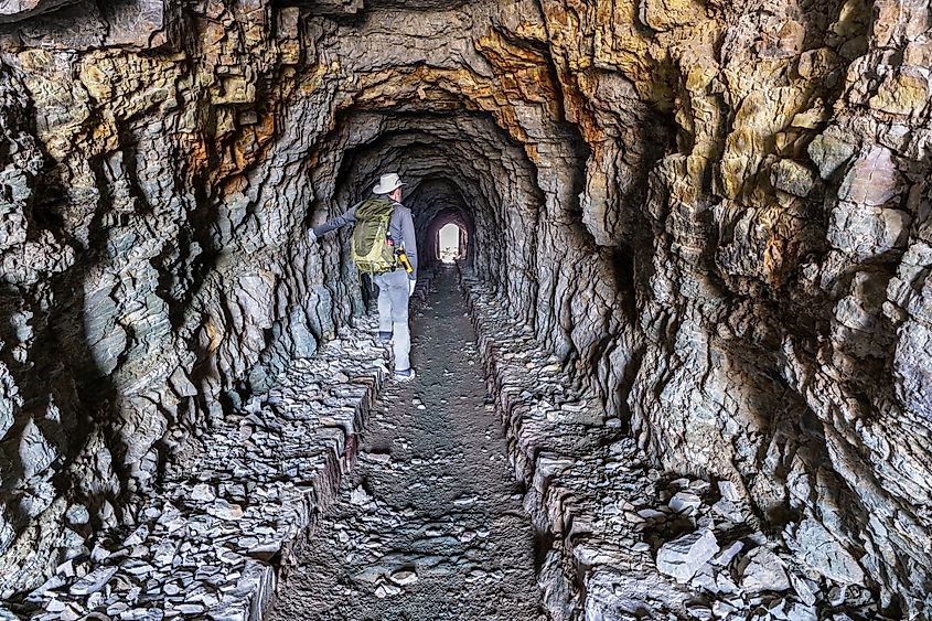 A hiker walking through the Ptarmigan Tunnel in Glacier National Park, Montana.