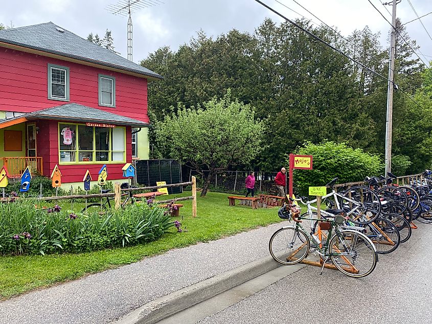 A full bike rack outside of a colourful house bistro 