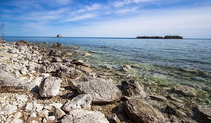 Les Cheneaux Islands In Lake Huron. Sunny day on the rocky coast of Lake Huron with the Les Cheneaux Islands at the horizon