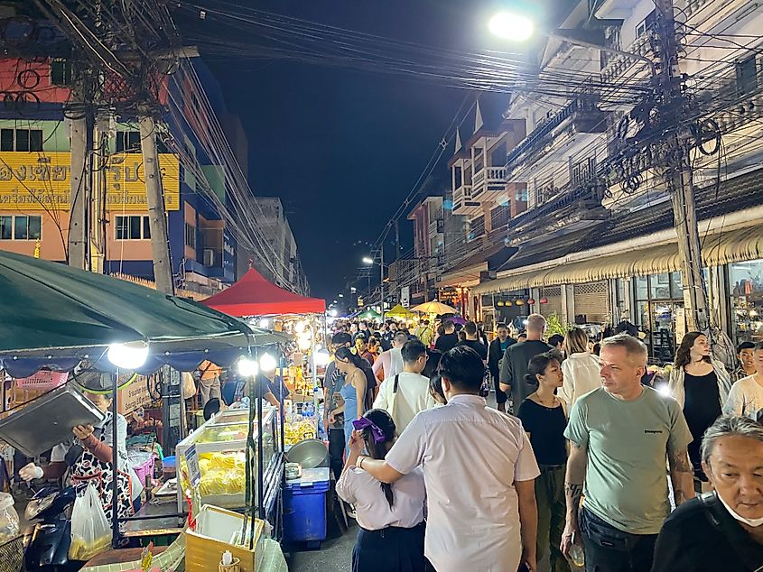 A colorful outdoor night market packed with people. 