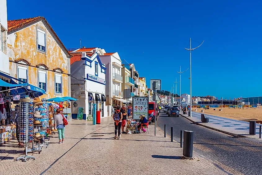 Nazaré, Portugal, with its iconic red-roofed houses lining the cliffs overlooking the Atlantic Ocean. 